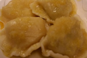My lunch.  On the left, two cheddar cheese and potato pierogi, on the right two mushroom and sauerkraut.  Not sure what sauce goes on them.  Butter and onion?  A cute boy of around ten sold them to me, instructing his Polish-speaking father about my order.  